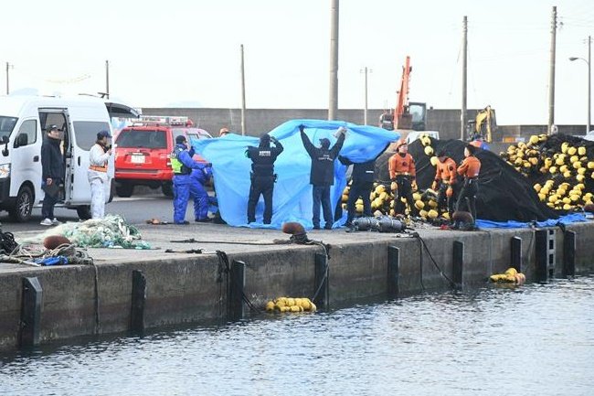 車が見つかった大社漁港を調べる関係者＝出雲市大社町杵築北