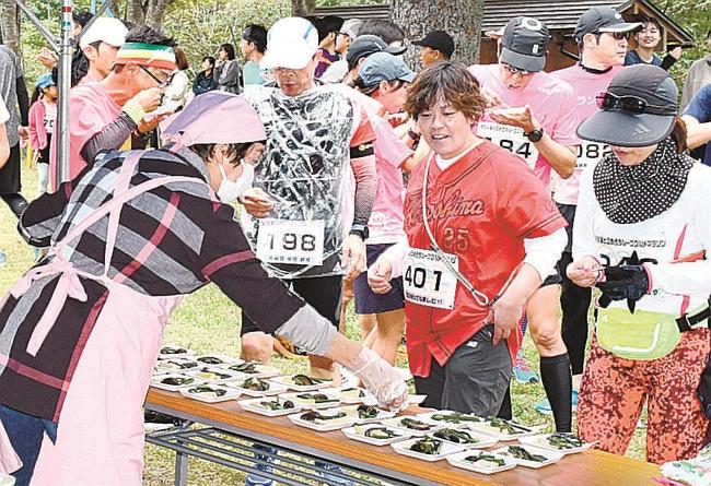コース途中のエイドステーションで野菜の煮しめなどを食べる参加者＝島根県奥出雲町下横田