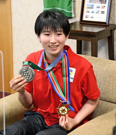 卓球女子団体の銀メダルと市スポーツ・文化顕章を手にほほ笑む山田萌心さん＝益田市常盤町、市役所