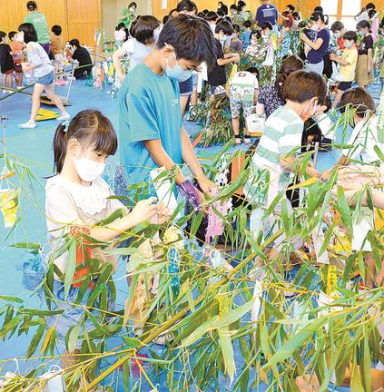 真剣な表情で短冊を結びつける津田小学校の児童＝松江市東津田町、津田小学校