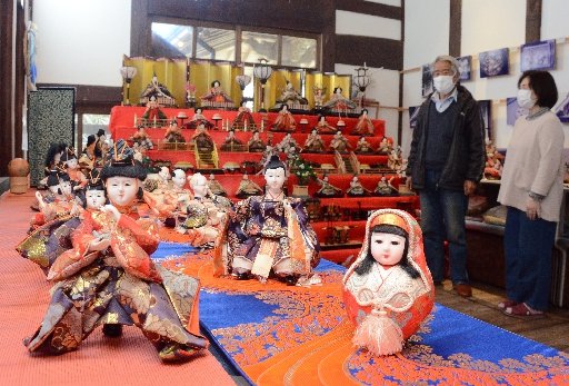 ずらりと並んだひな人形を紹介する中田豊センター長（左）＝大田市大森町、大森まちづくりセンター