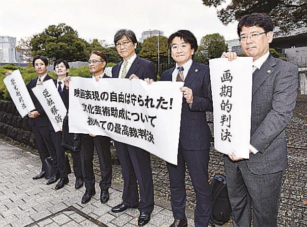映画への助成金を巡る訴訟の上告審判決後「画期的判決」などと書かれた紙を掲げる原告側の弁護士たち＝１７日午後、最高裁前
