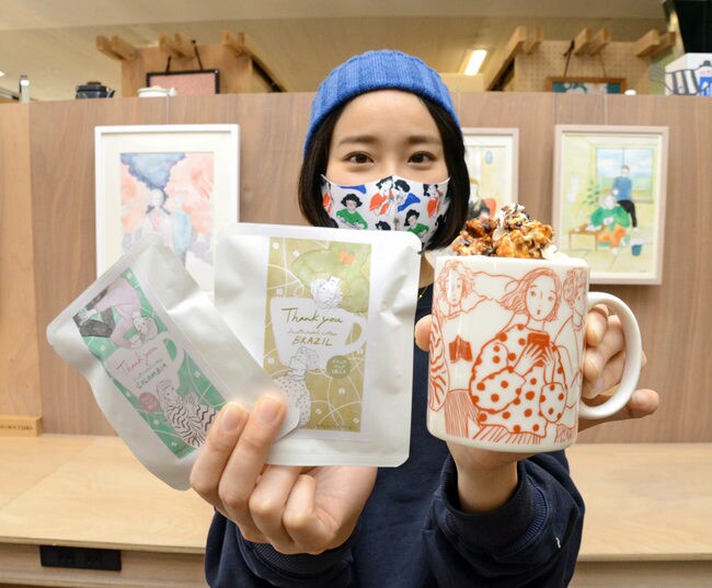 イラストを描いたマグカップとドリップバッグコーヒーを手にする伊吹春香さん=米子市新開2丁目、SHIMATORI米子店