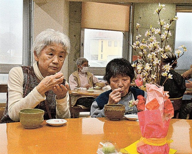 桜の生け花を眺めながら自分で作った和菓子を楽しむ入居者＝江津市和木町、よろこぼう屋