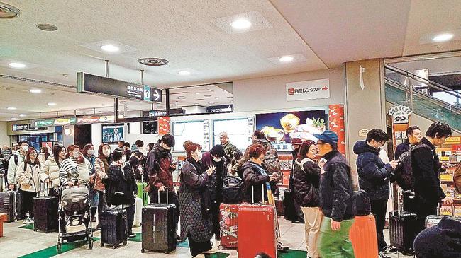 羽田行の第１便が欠航となり、払い戻しなどのため列に並ぶ人たち＝出雲市斐川町沖洲、出雲空港