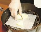 チーズがくっつかないように網の上にクッキングシートをのせる＝東京都文京区