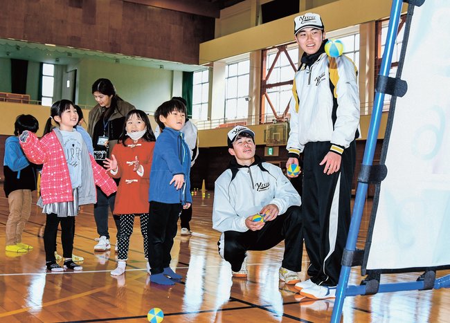 安来高校の野球部員が見守る中、ボールを投げる児童＝安来市伯太町西母里、伯太体育館