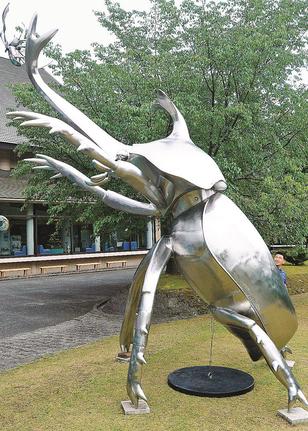 玄関前の芝生に設置された高さ６メートルのカブトムシのステンレス製彫刻＝大田市三瓶町、島根県立三瓶自然館サヒメル