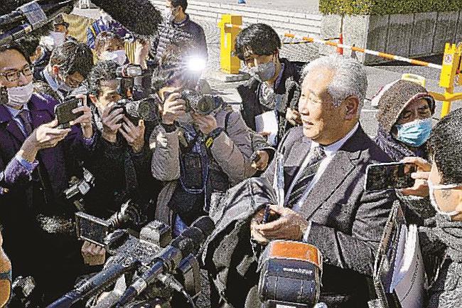 日野町事件の再審開始が認められ、報道陣に囲まれる阪原弘元受刑者の長男弘次さん（右）＝２月２７日午後、大阪高裁前