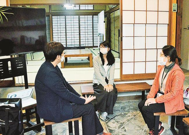 認知症カフェを開設するフリースペースで教員２人と話し合う内田美羽さん（中央）＝出雲市平田町