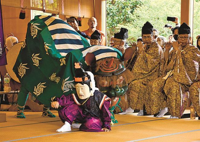 奉納された蓮華会舞で、獅子にかまれて目を覚ます眠り仏＝島根県隠岐の島町池田、隠岐国分寺