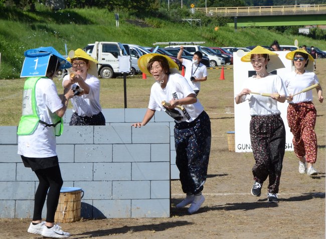 竹製の水鉄砲を使い熱戦を繰り広げる参加者＝安来市広瀬町広瀬、飯梨川河川敷