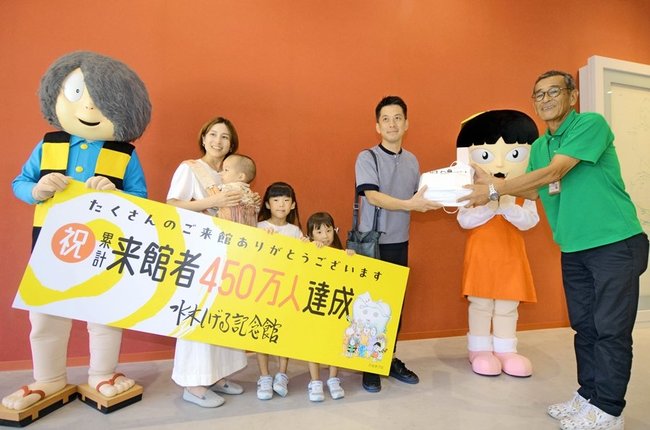 庄司行男館長（右）から記念品を受け取る時見直幸さん＝境港市本町、水木しげる記念館