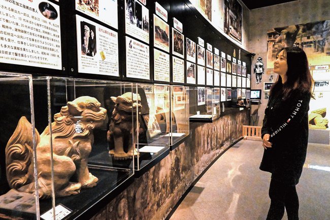 来待石で作られた出雲狛犬の資料を見る来館者＝松江市宍道町東来待、来待ストーン