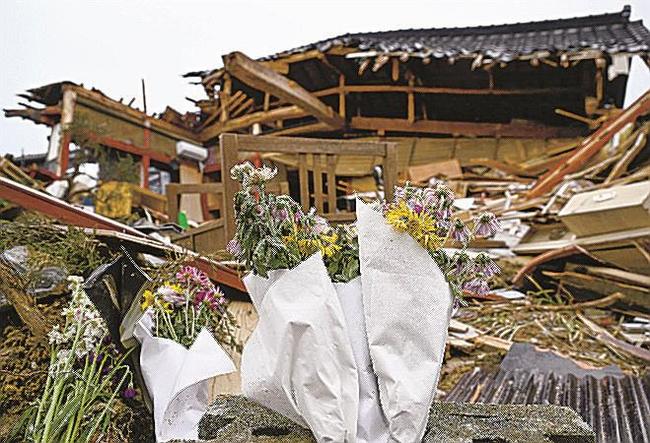 石川県珠洲市の倒壊した家屋の前に手向けられた花＝１９日