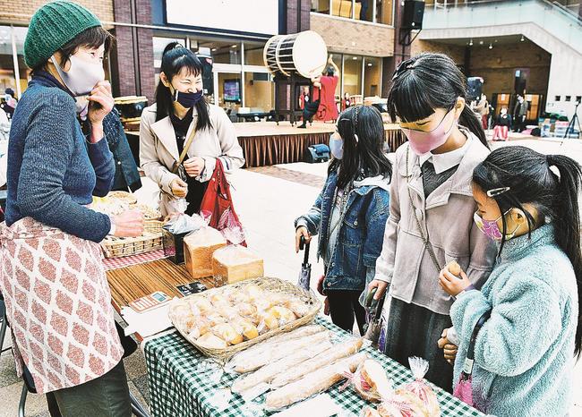 再開した江津駅前市場を訪れ、買い物する子どもたち