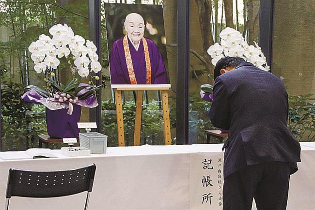瀬戸内寂聴さんの訃報を受け、徳島県立文学書道館に設置された記帳台で手を合わせる人＝１２日午前、徳島市