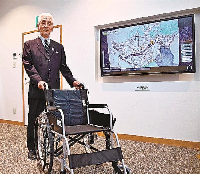 寄贈した車いすを紹介する溝口武男代表=益田市本町、れきしーな