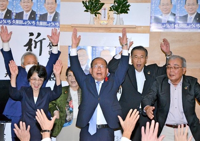 ３選を決め、支持者らと万歳三唱する久保田章市氏（中央）＝１７日午後１０時２４分、浜田市黒川町、事務所