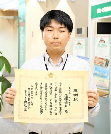 大田署から感謝状を受け取った佐藤僚太さん＝大田市長久町、島根銀行大田支店