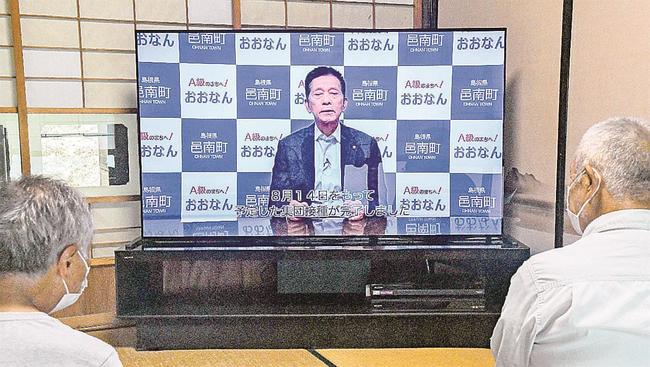 ケーブルテレビで集団接種完了を報告する自治体の放送を見る住民＝島根県邑南町内