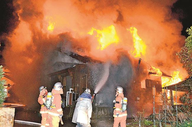 炎を上げ燃える民家＝３日午前１時２３分、米子市福万