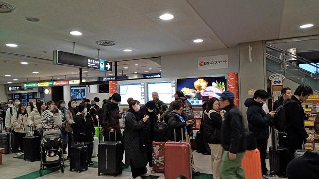 航空機衝突事故の影響で羽田行の第１便が欠航となり、払い戻しなどのため列に並ぶ帰省客ら＝３日、出雲市斐川町沖洲の出雲空港
