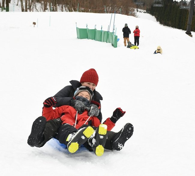 キッズパークでそり遊びをする家族連れ＝島根県邑南町市木、瑞穂ハイランド