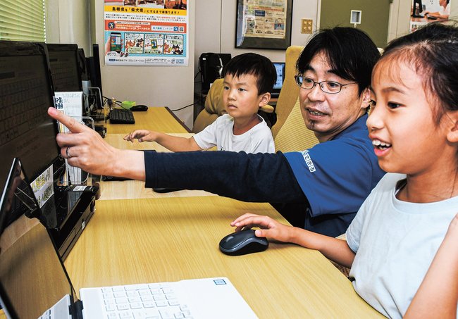 長谷川浩二さん（中央）の指導でプログラミングを学ぶ子どもたち＝松江市東奥谷町、わかるとできる松江城北校