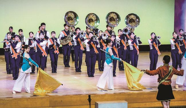 息の合った演奏と踊りで華やかなステージを披露する北陵高校吹奏楽部員=出雲市塩冶有原町2丁目、市民会館