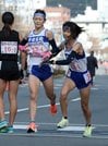 平田の４区田辺心（左）からたすきを受け、駆け出す５区本田琴弓‖西大路下立売、第４中継所 