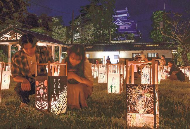 あんどんの幻想的な光を楽しむ来場者＝23日午後6時50分、松江市殿町、松江城二の丸上の段