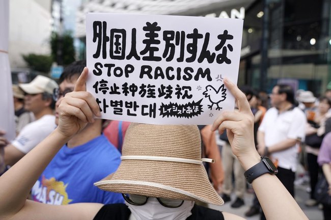 参院選の街頭演説会場で外国人差別に抗議する人＝１９日、東京・銀座