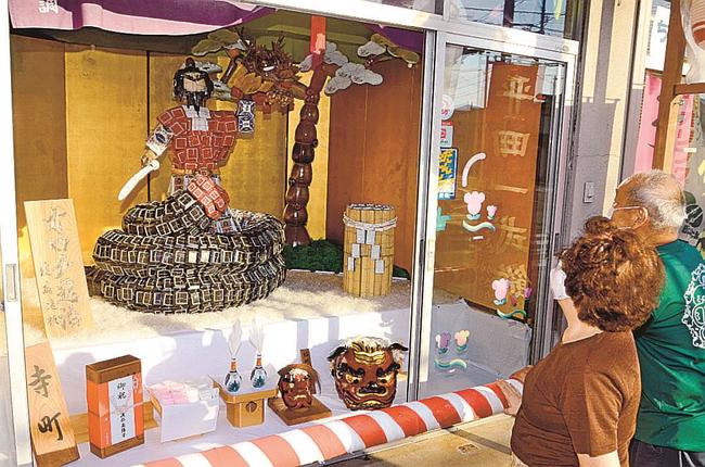 寺町が制作した「オロチ退治（コロナ退治）」に見入る市民＝出雲市平田町