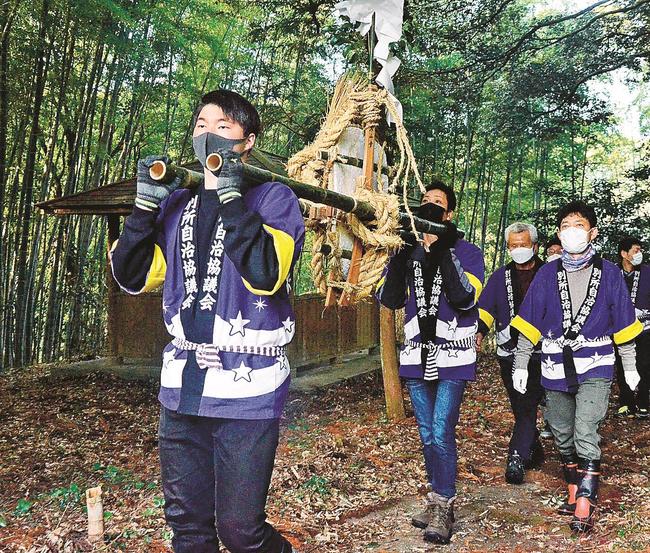 大餅を担いで険しい山道を登る地元住民＝松江市八雲町東岩坂、星上山