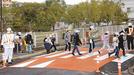 仮設された「スムーズ横断歩道」を渡る児童＝松江市学園１丁目