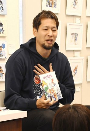 絵本を手に個性の大切さについて説明する谷口大智選手＝松江市黒田町、ＪＵ米子高島屋ギフトサロン松江