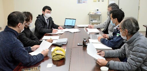 「因幡麒麟獅子舞の会」メンバーに質問を募る記者（奥左）＝鳥取市吉方温泉３丁目、市文化センター