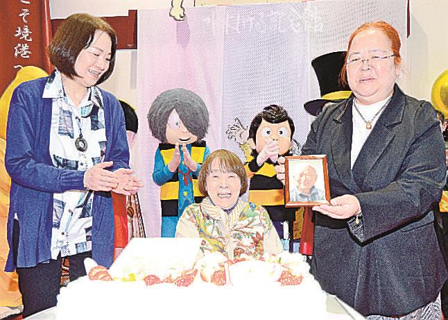 ファンから祝福され笑顔を見せる水木しげるさんの妻・武良布枝さん（中央）と、娘の原口尚子さん（左）、武良悦子さん（右）＝境港市大正町、みなとさかい交流館