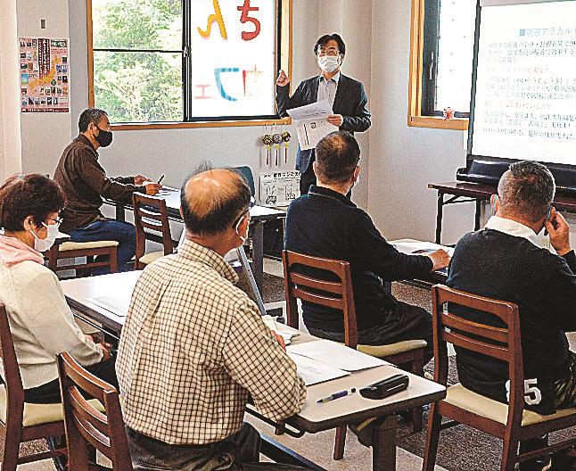 松村健次論説委員長（奥）の解説に耳を傾ける参加者＝松江市田和山町、さんさんカフェ