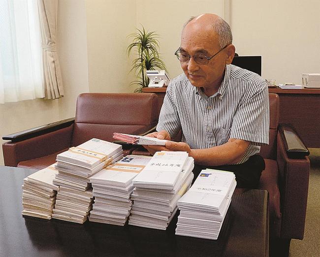 寄付金が入っていた封筒の束に目を通す山本勝昭会長＝島根県奥出雲町三成