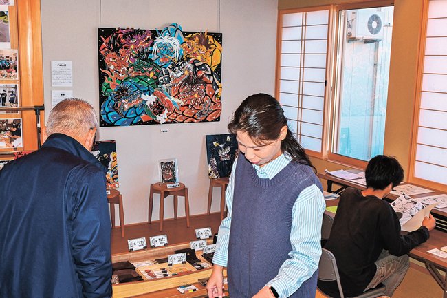 ユニークな感性が光る作品を鑑賞する関係者=益田市常盤町、グループホームふぁみりえ