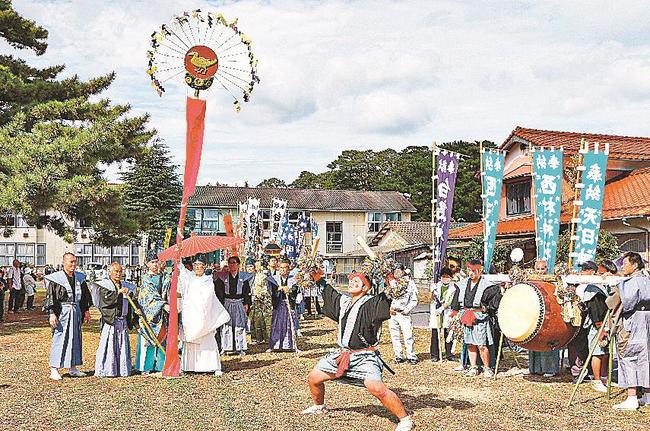 金のカラスが彫刻されたご神体を前に陰陽胴打ちを披露する男衆＝島根県隠岐の島町中村