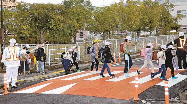仮設された「スムーズ横断歩道」を渡る児童＝松江市学園１丁目