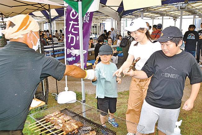 石見和牛の串焼きを購入する来館者＝浜田市・江津市、水族館アクアス