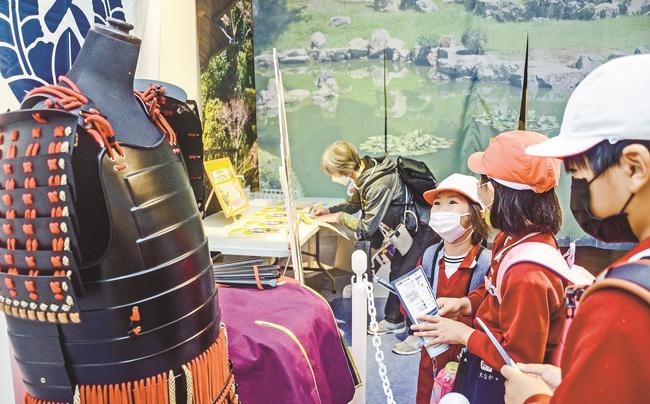 益田氏の家紋入り甲冑に見入る来場者＝浜田市・江津市、しまね海洋館アクアス