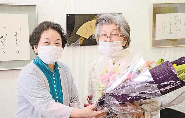 受講生から花束を受け取る柳田幸子さん（右）＝松江市殿町、山陰中央新報殿町ギャラリー