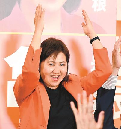 当選確実となり、支持者と万歳して喜ぶ亀井亜紀子氏＝松江市御手船場町、労働会館