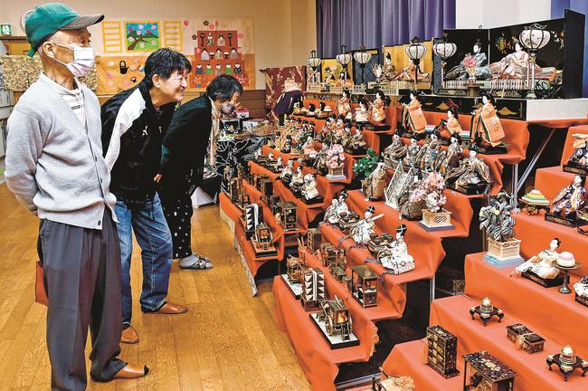 地域住民が持ち寄ったひな人形に見入る来場者＝安来市広瀬町布部、布部交流センター