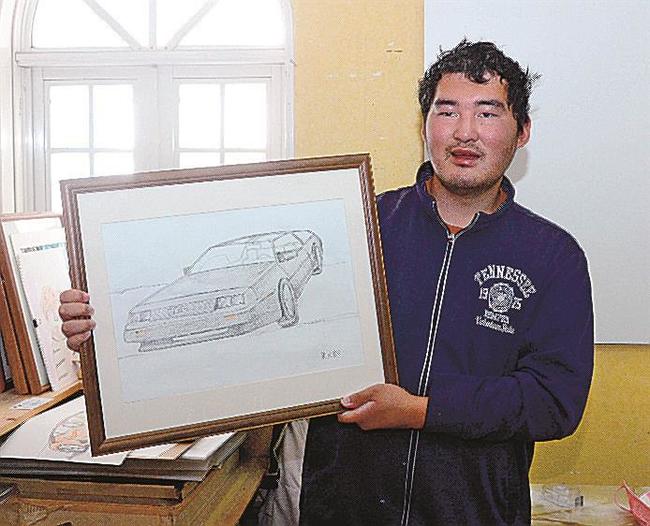 デロリアンの絵を手にする今岡凜太郎さん＝出雲市東福町、サポートセンターどりーむ
